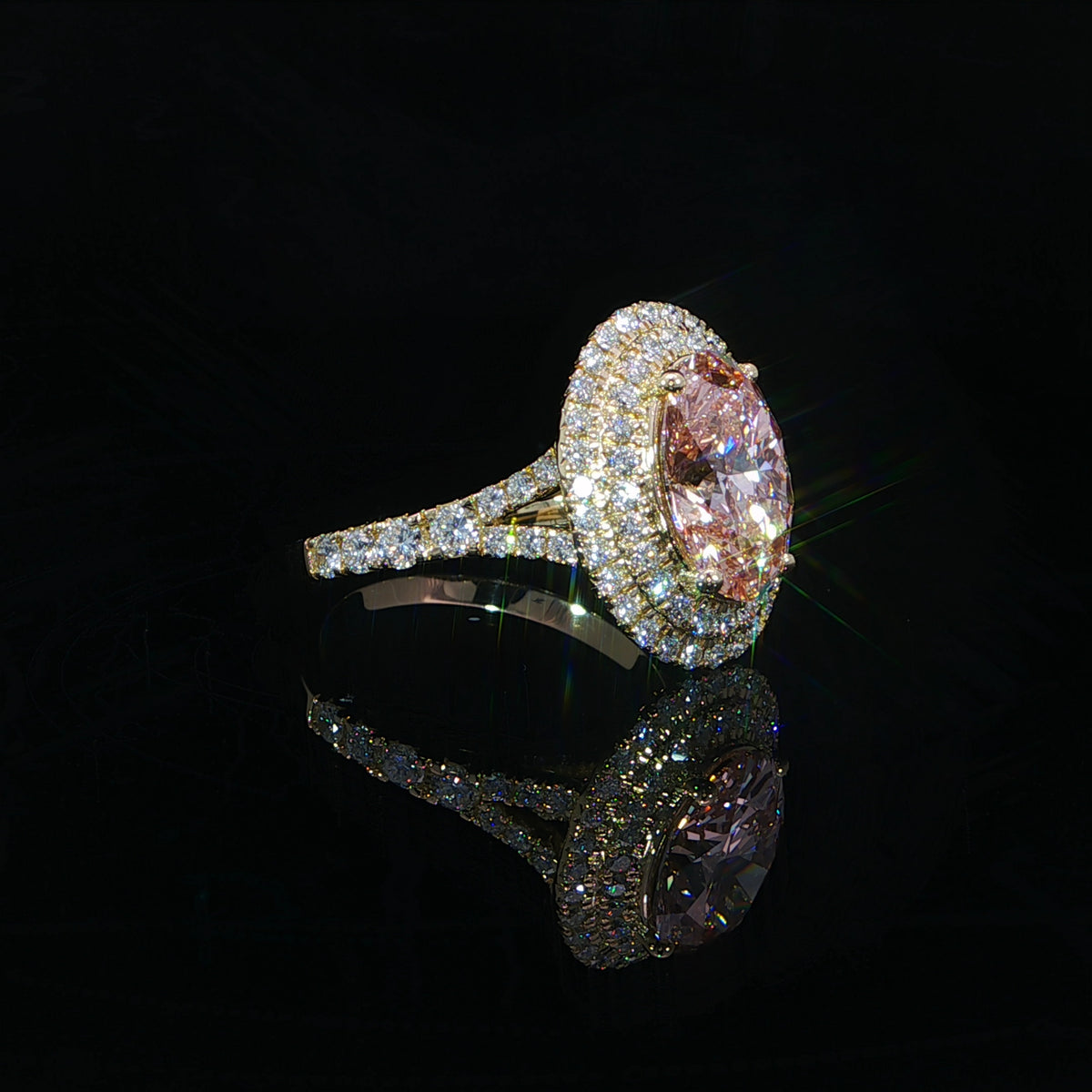 Fancy intense pink oval diamond engagement ring with a split shank and hidden halo in 14K yellow gold.