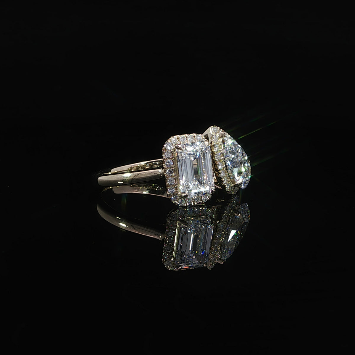 Lab grown diamond engagement ring with emerald cut and pear shaped center stones in a two-stone design.