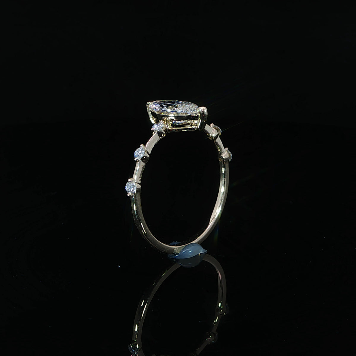 Close view of the spaced round diamonds decorating the 14K yellow gold engagement ring band.