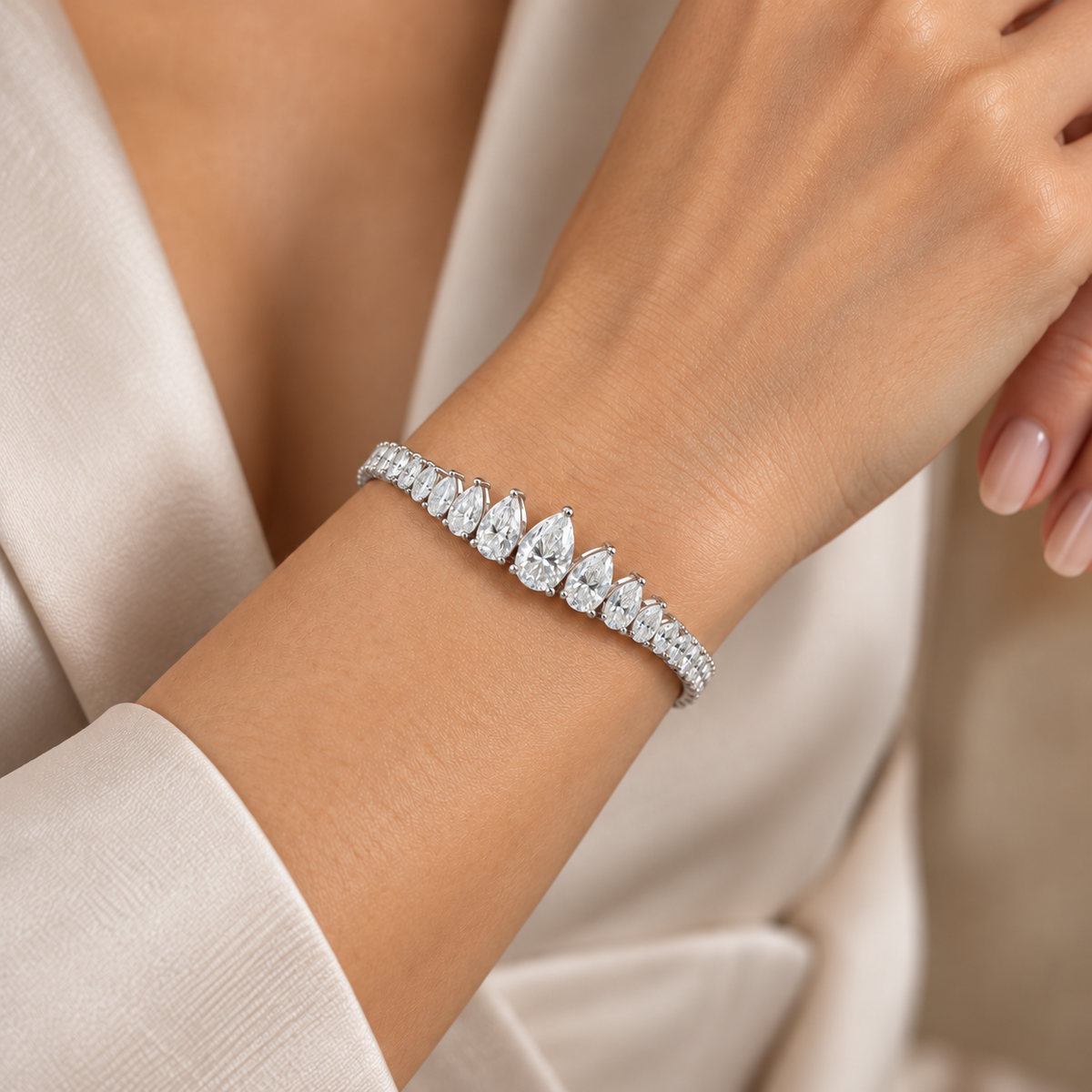Female model wearing the graduated pear moissanite bracelet at realistic wrist scale.