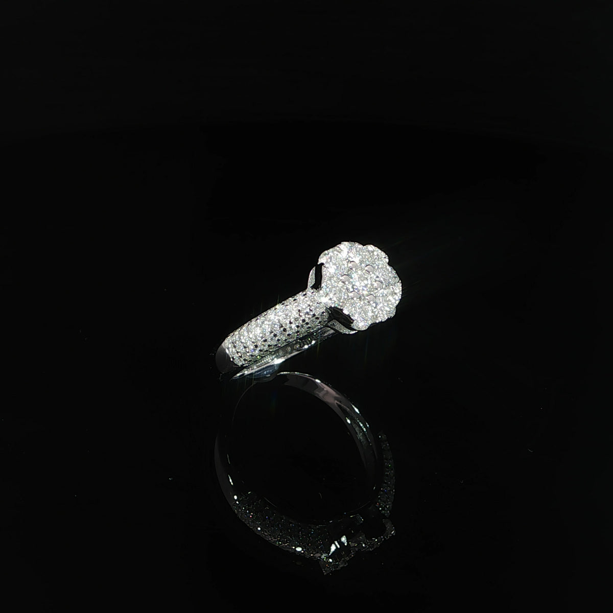 Angled view of the raised round cluster and pavé-covered domed shoulders.
