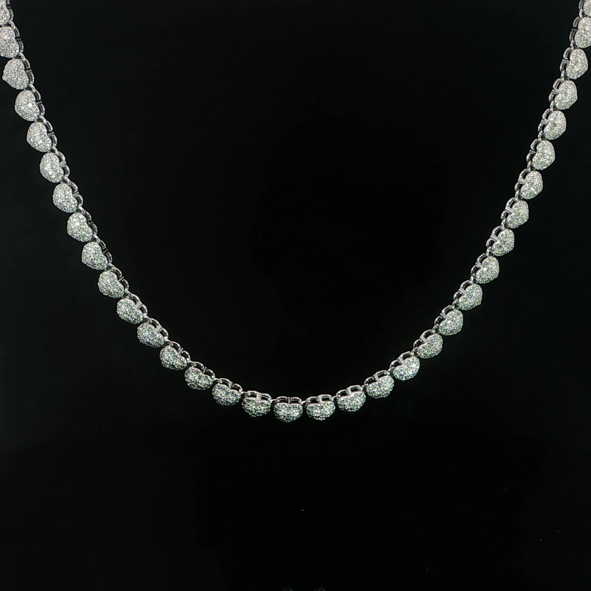 Front view of a petite heart moissanite tennis necklace in sterling silver