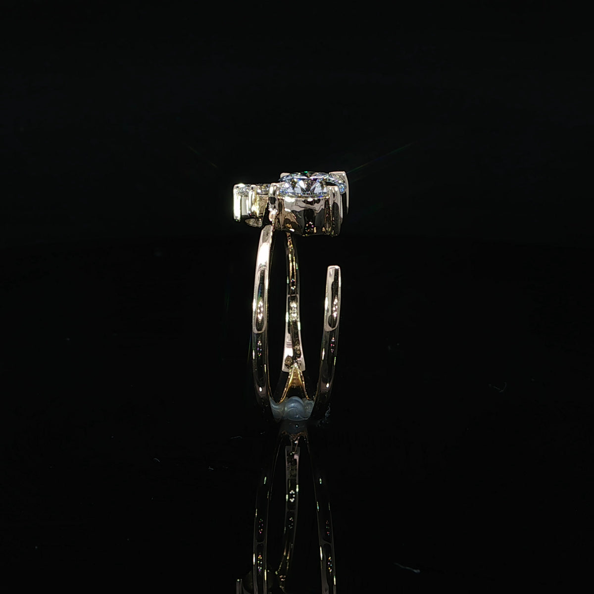 Side detail of the smaller diamond’s raised yellow gold setting.