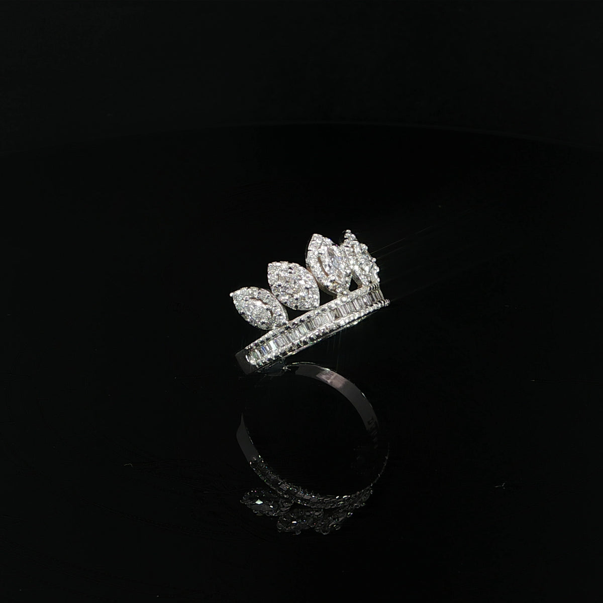 Angled view of a 14K white gold crown ring with graduated marquise diamonds and a polished shank.