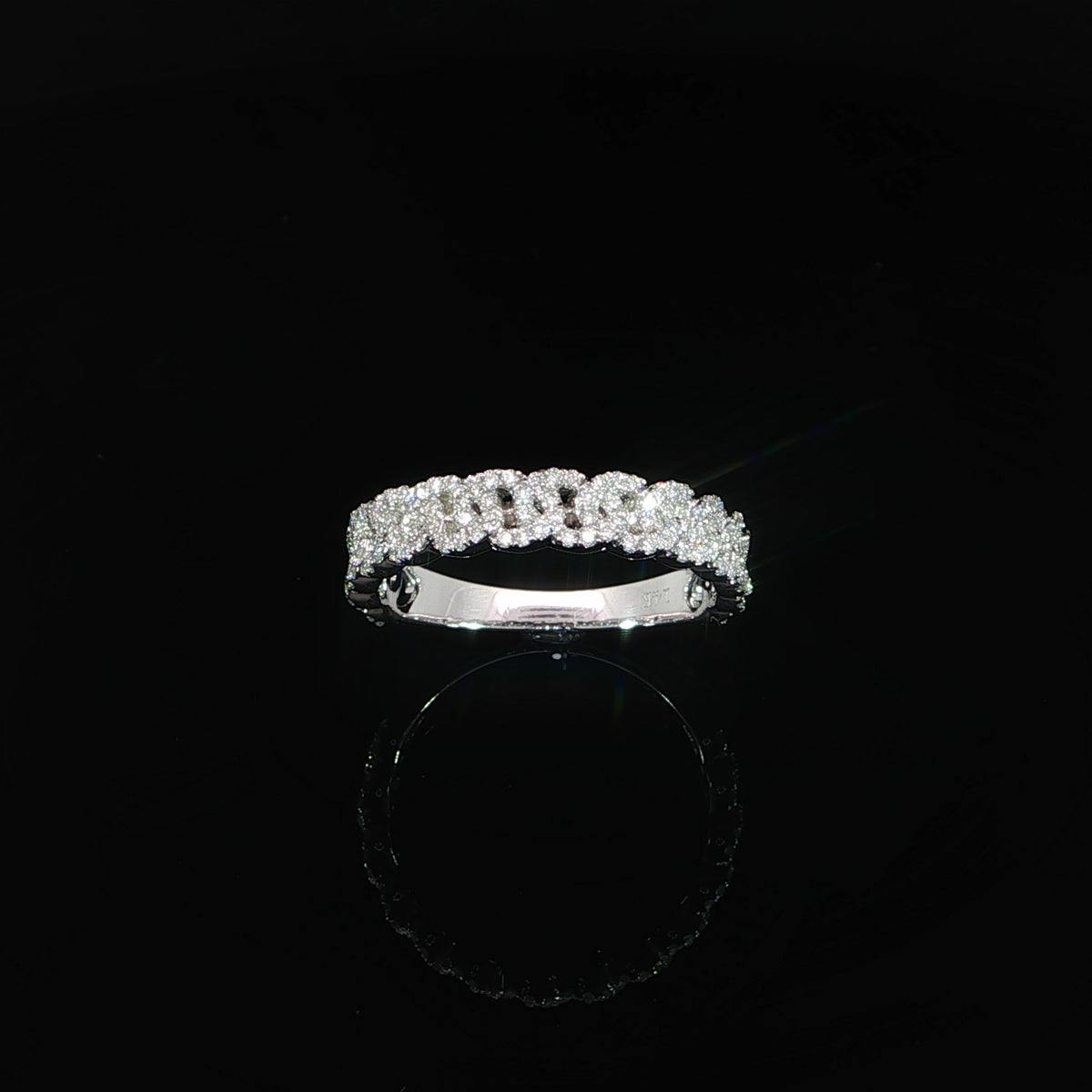 Tilted view of a white gold pavé diamond ring with interlocking link motifs and a polished inner band.