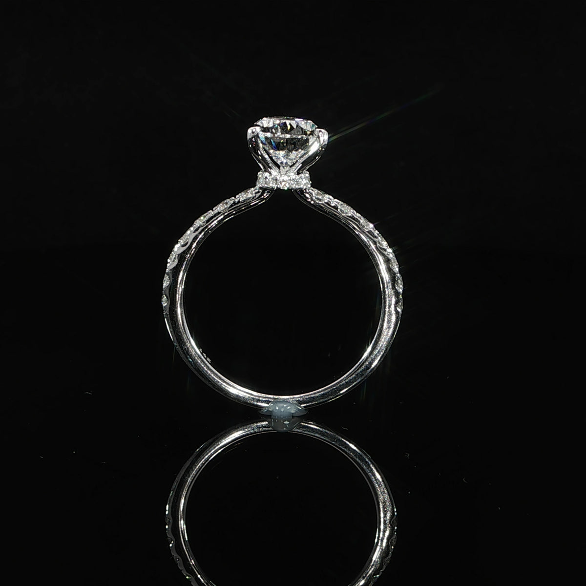 Side profile of a pear diamond ring showing the raised setting, hidden halo, and pavé diamond band.