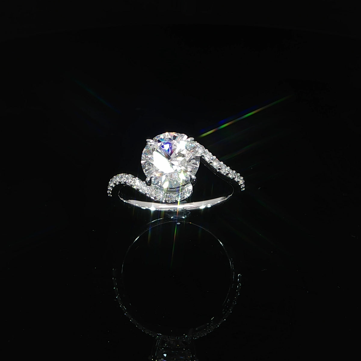 Top view of a white gold engagement ring with a round center diamond and curved bypass band.