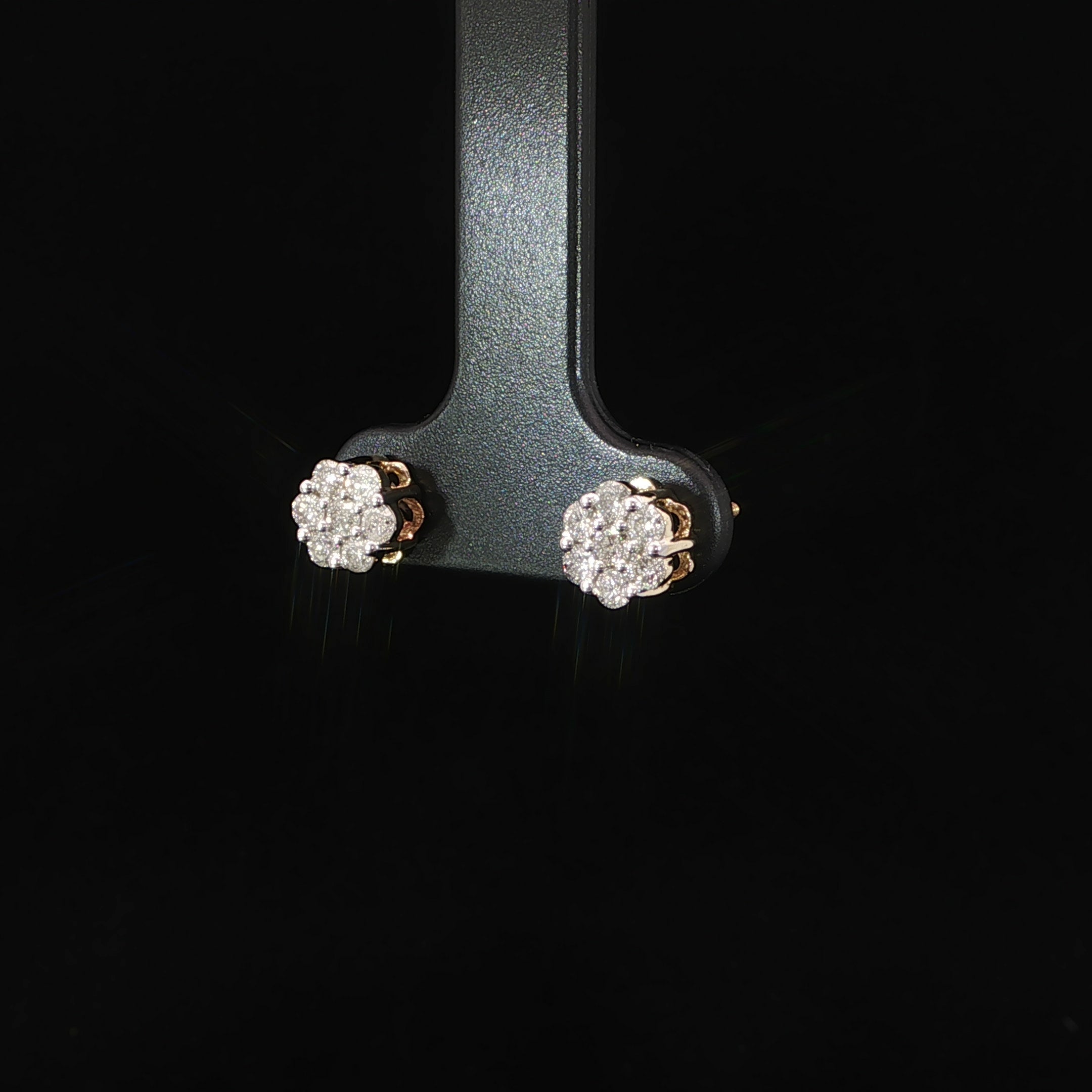 Angled view of yellow gold diamond cluster stud earrings