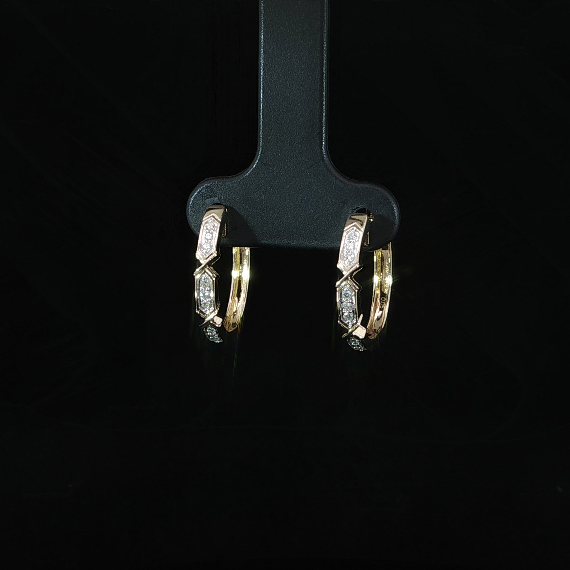 Angled view of yellow gold geometric diamond hoop earrings
