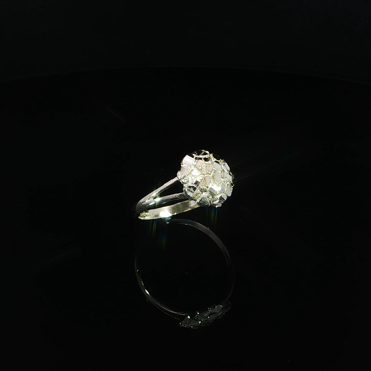 Angled view of a yellow gold nugget ring showing triangular openings where the band splits beneath the circular top.