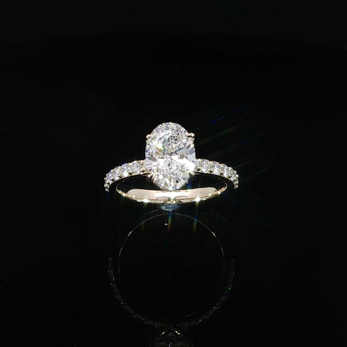 Top view of a yellow gold oval engagement ring with a diamond-accented band.