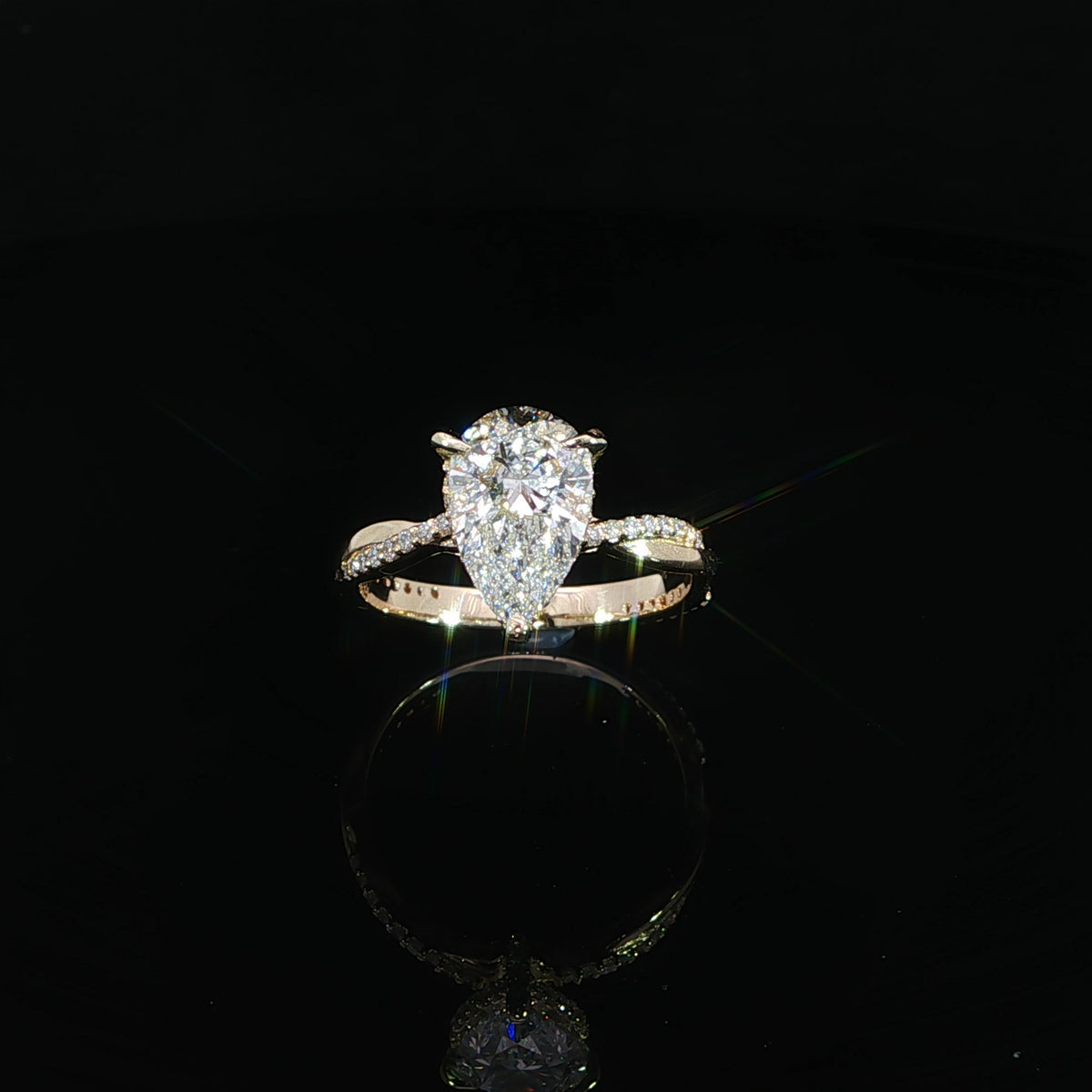 Top view of the pear diamond centered above the slender twist band.