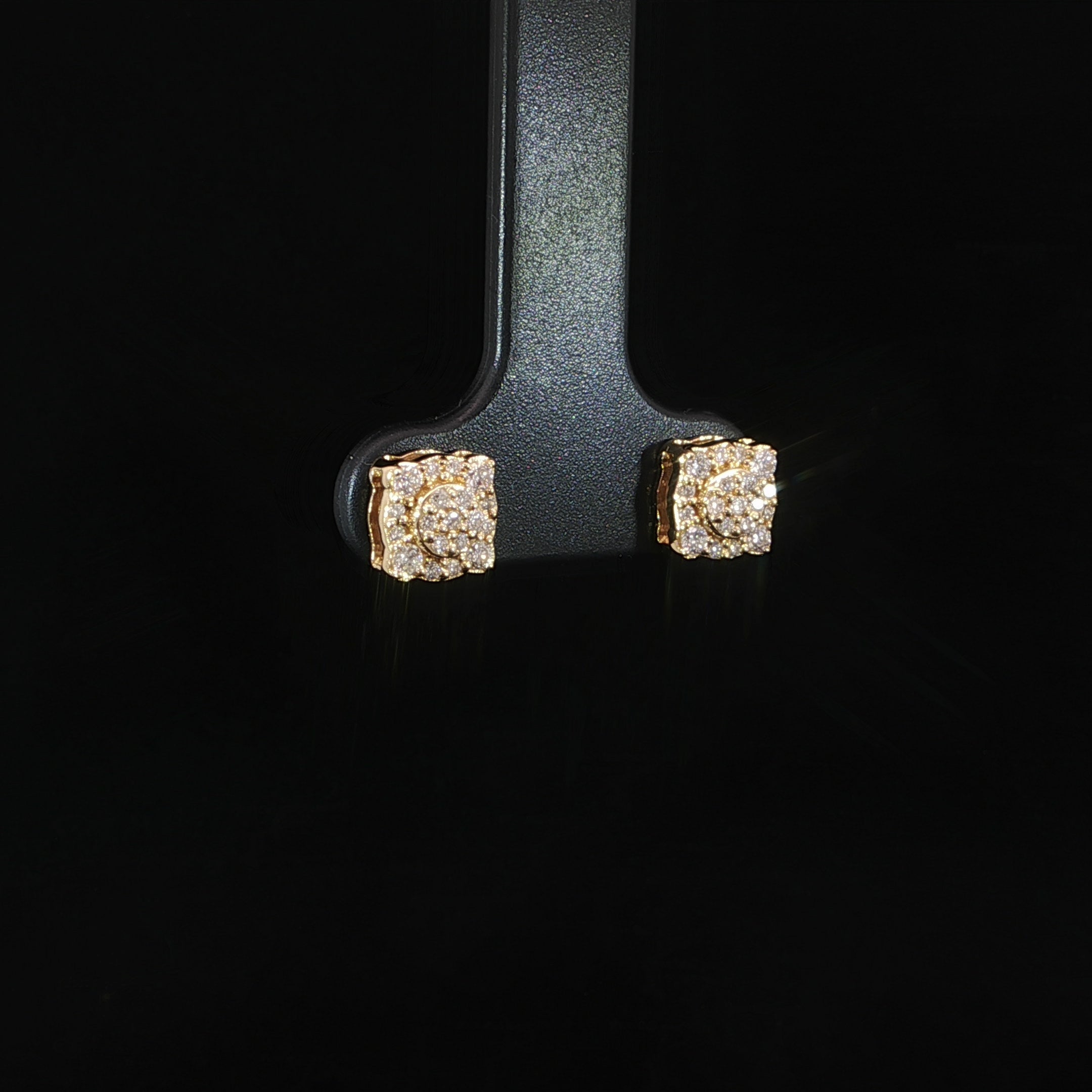 Angled view of yellow gold round center cluster halo earrings