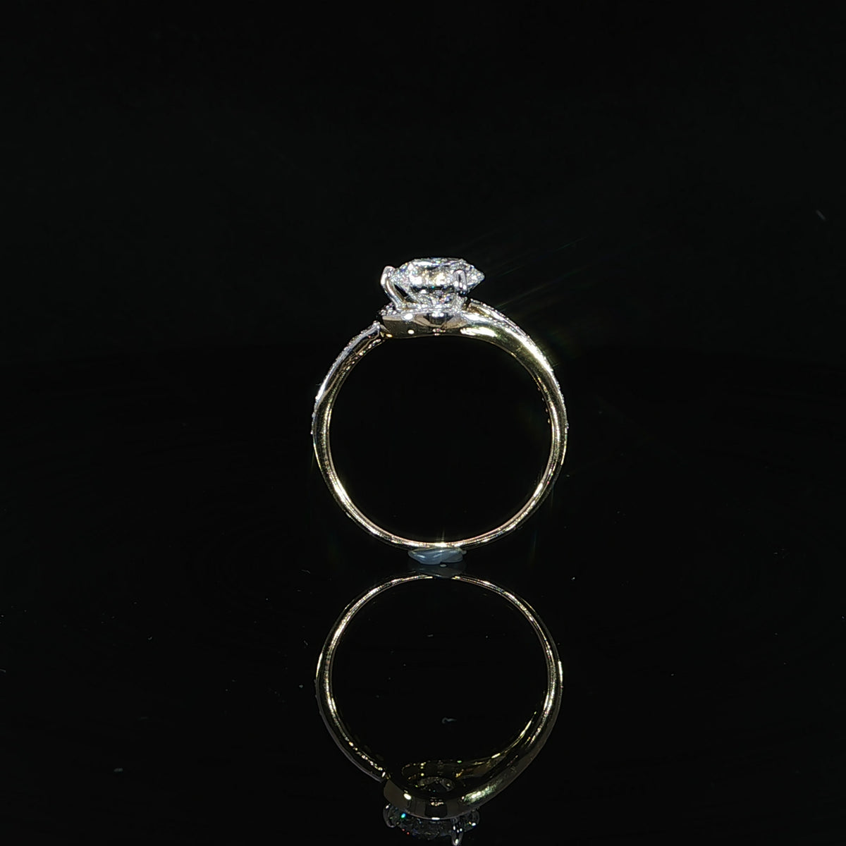 Yellow gold engagement ring featuring a round center diamond and sweeping diamond-set bypass design.