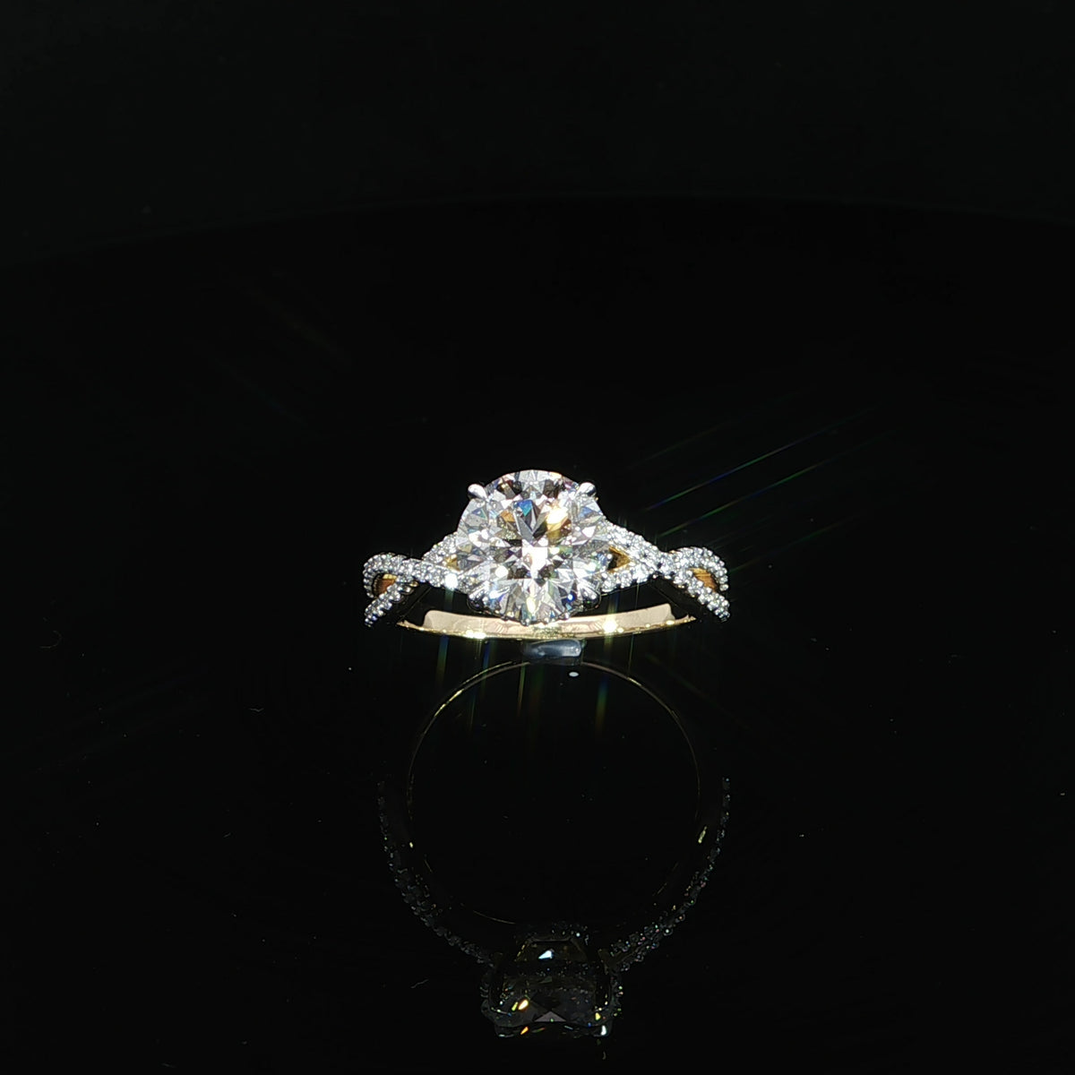 Top view of a yellow gold engagement ring with a round center diamond and intertwined diamond band.
