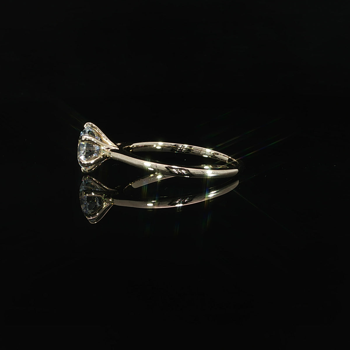 Side profile of a yellow gold solitaire showing the raised round diamond and slender polished band.